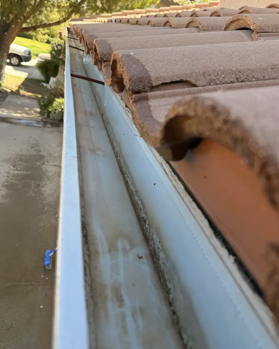 After: Gutter packed with dirt, and the same gutter after cleaning