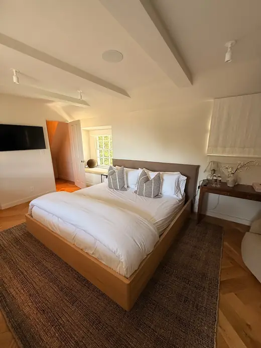Bedroom with a beamed ceiling and herringbone floors