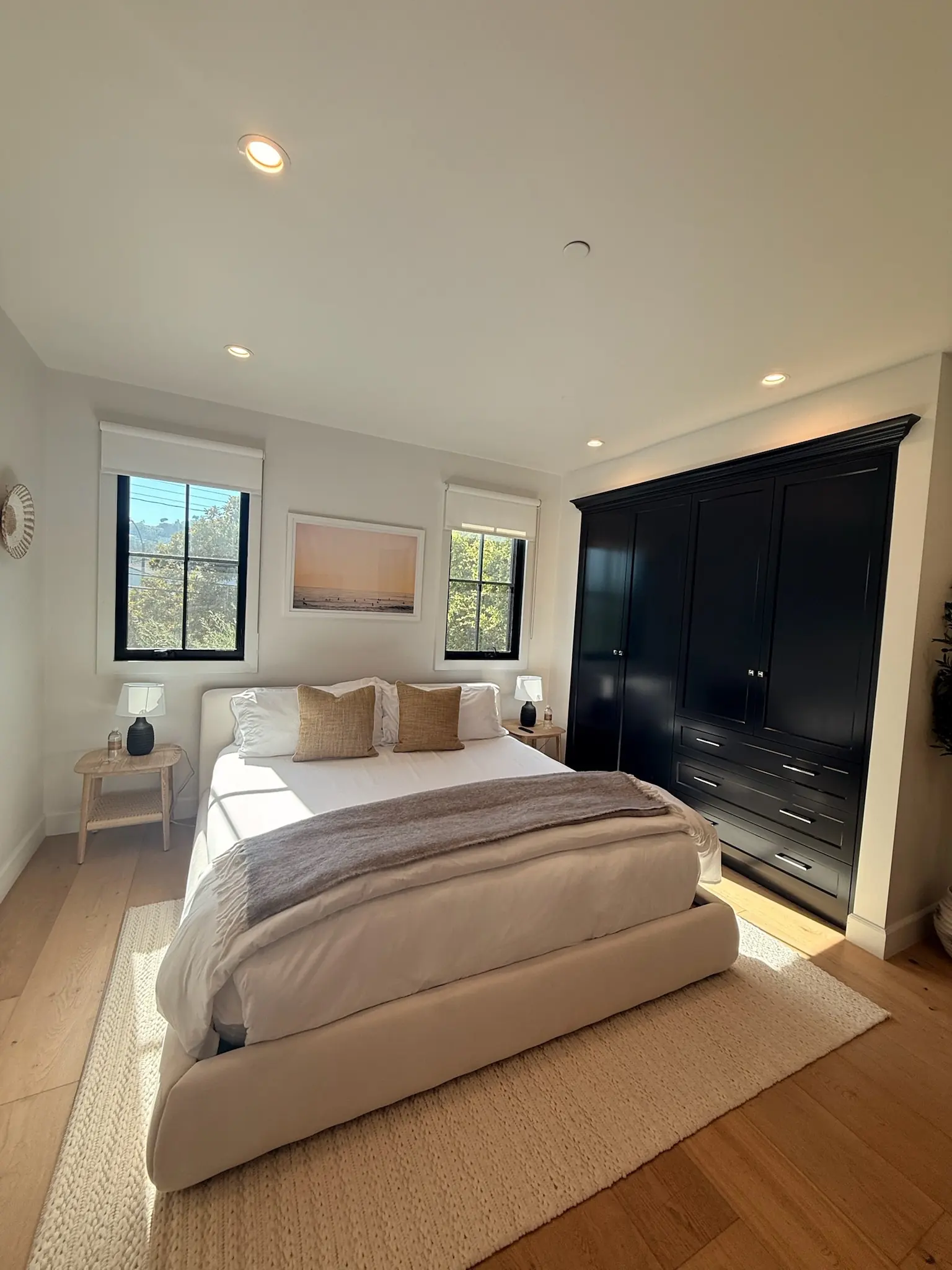 Bedroom with neutral bedding and a black built-in wardrobe