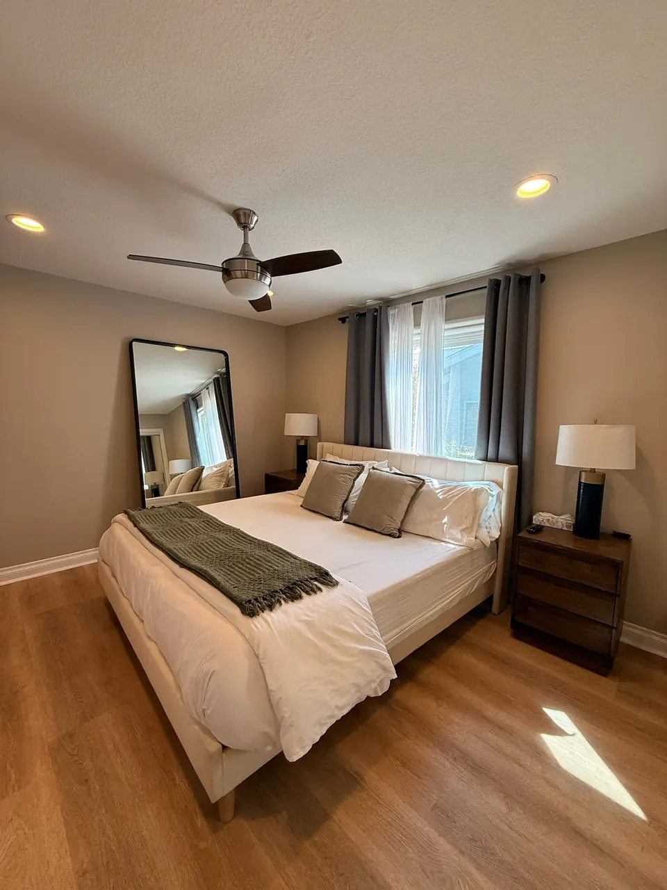 Bedroom with a ceiling fan and neutral bedding