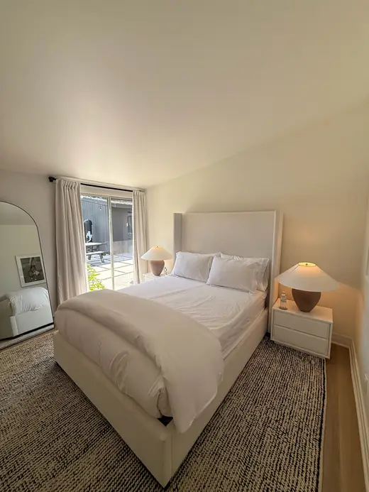 Neutral bedroom with linen bedding and a woven rug