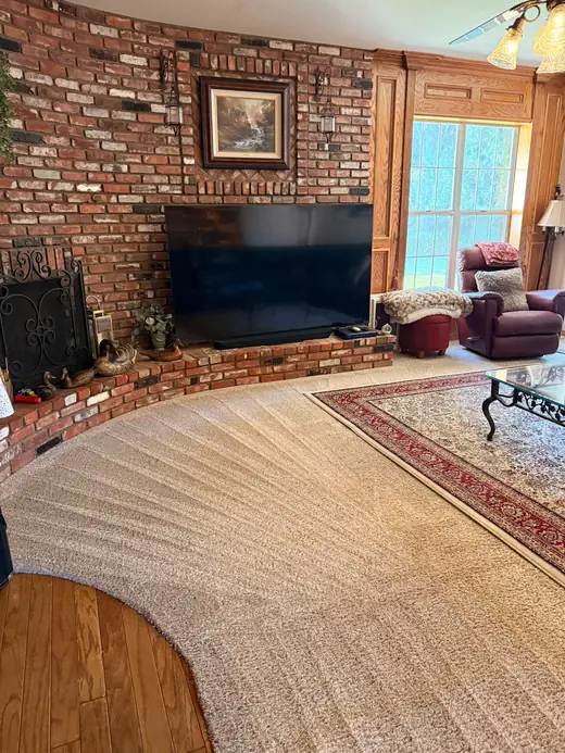 Cleaned carpet in a family room with a brick fireplace