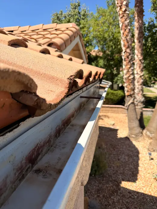 Clean gutter along a tile roof below a gable