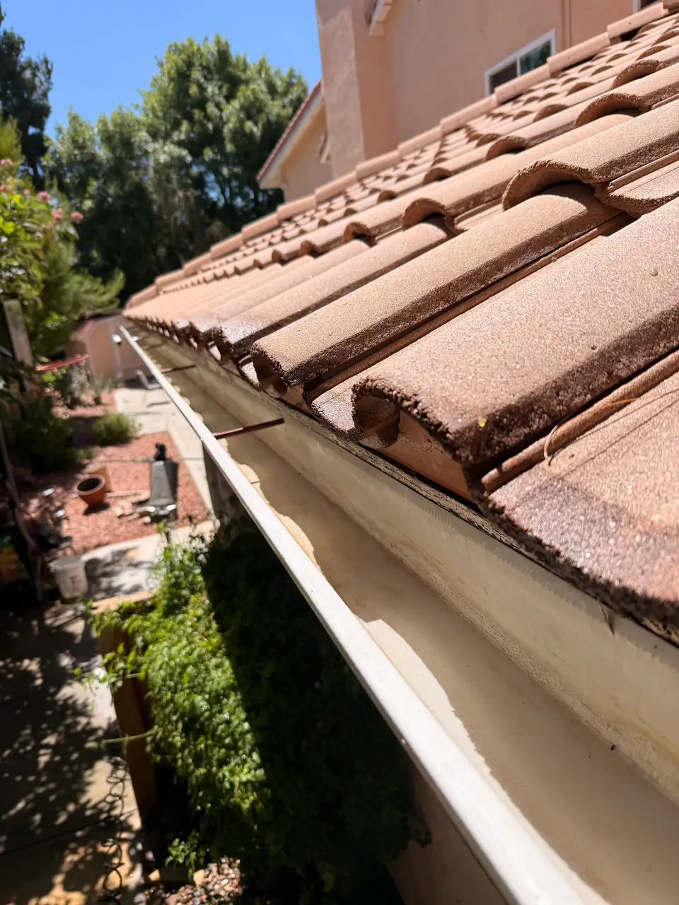 Clean gutter running along a tile roof after cleaning