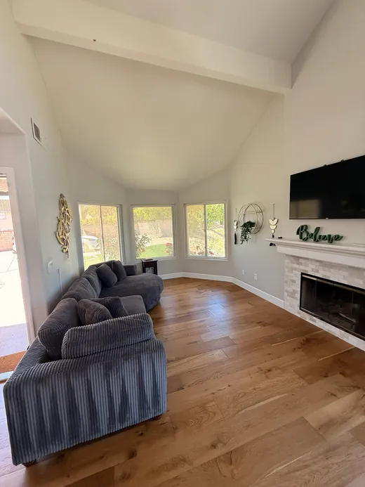 Living room with a vaulted ceiling, sectional and fireplace