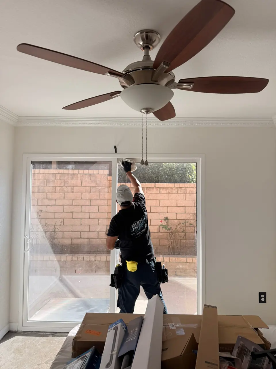 Team member cleaning around a sliding glass door in an empty room