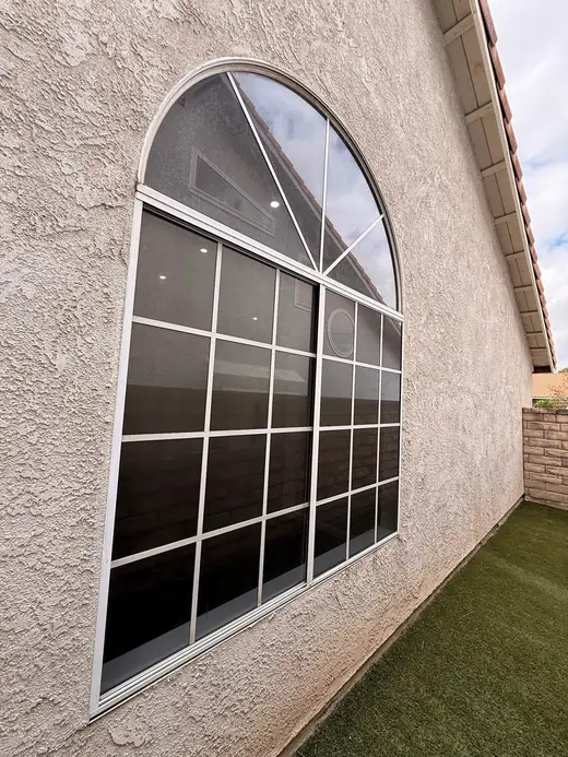 Large arched window on a stucco home
