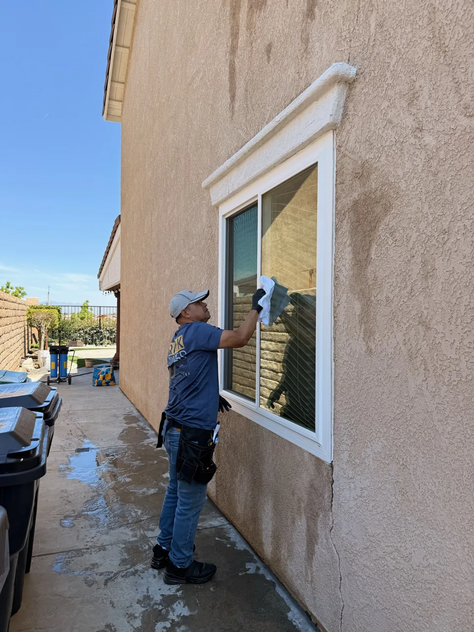 Team member wiping an exterior window on a two-story home