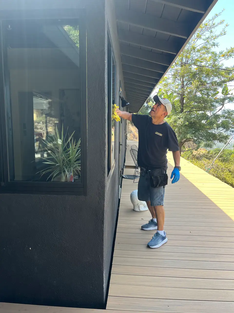Team member wiping a window along a wraparound deck