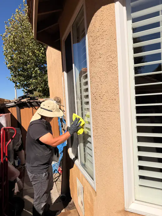 Team member detailing a window with a microfiber cloth
