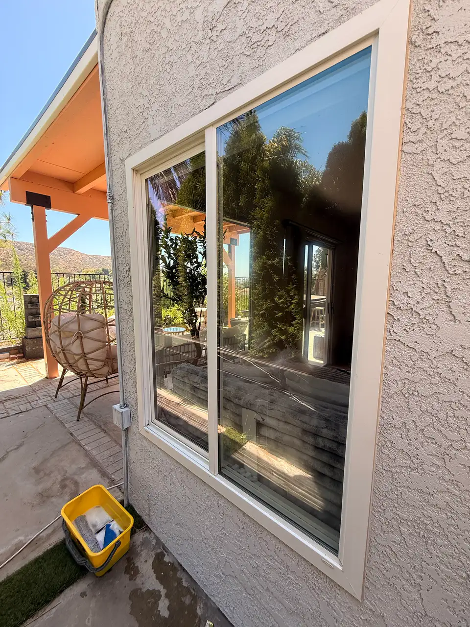 Clean sliding window beside a covered patio