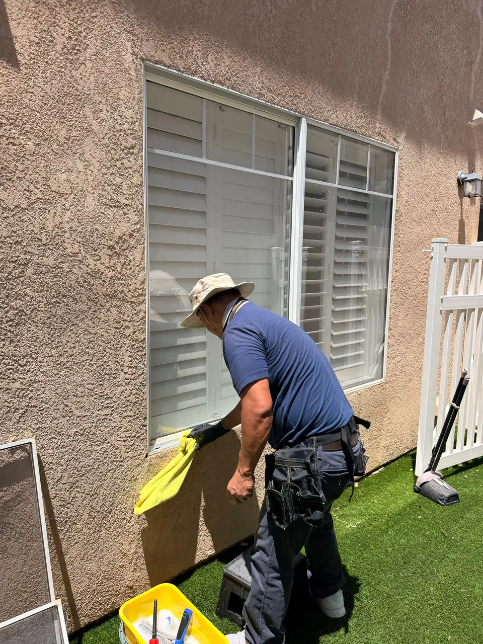 Team member wiping down a window sill and frame