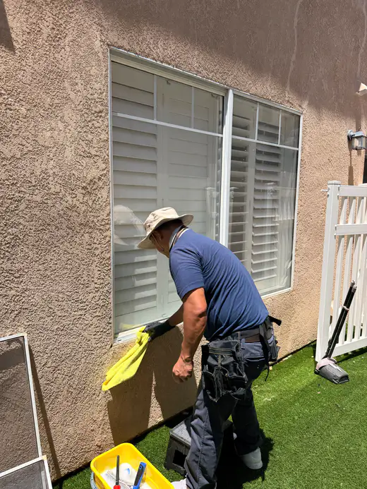Team member wiping down a window sill and frame